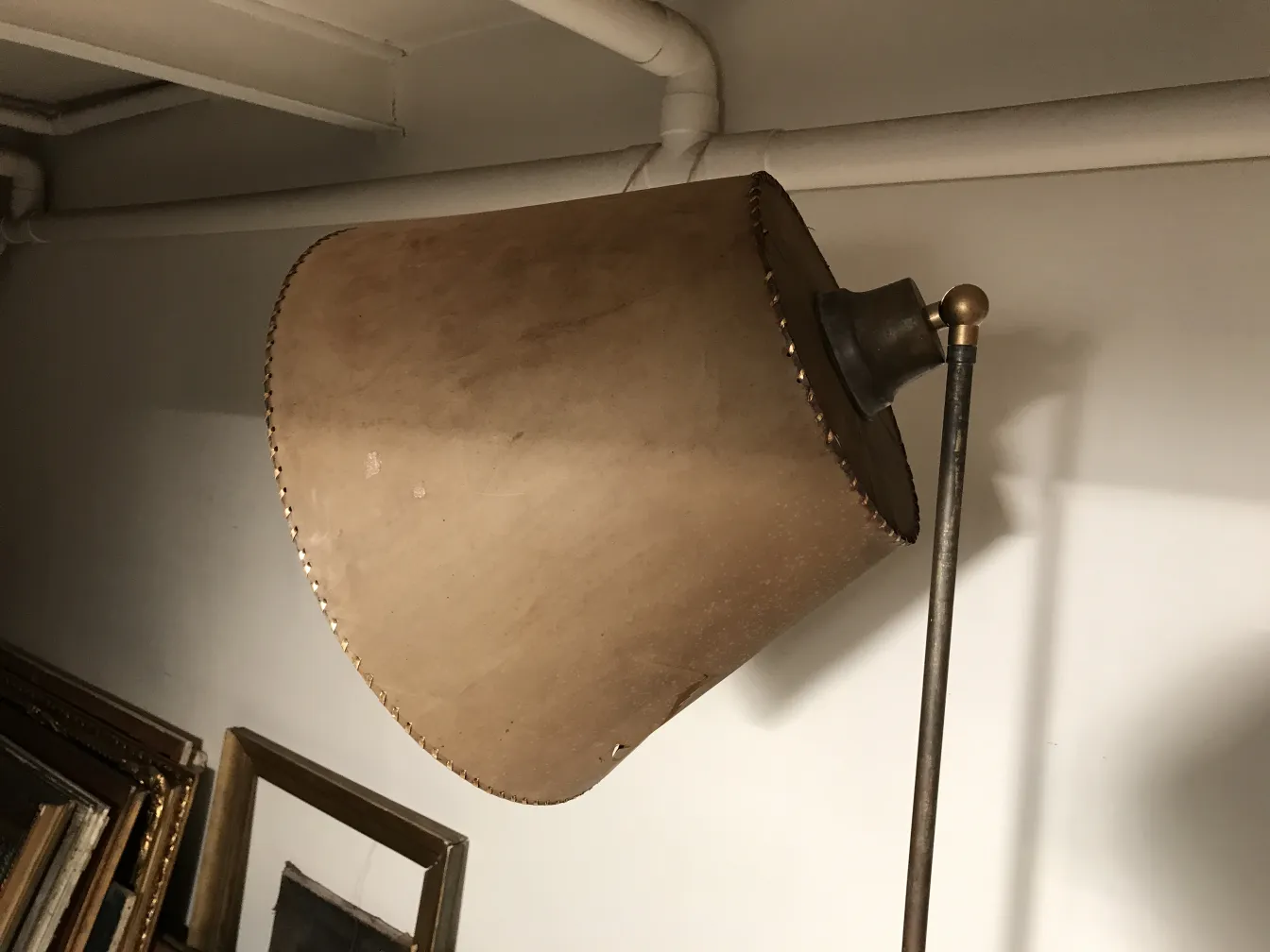 Lampada da terra antica con paralume in tonalità calde e dettagli dorati.