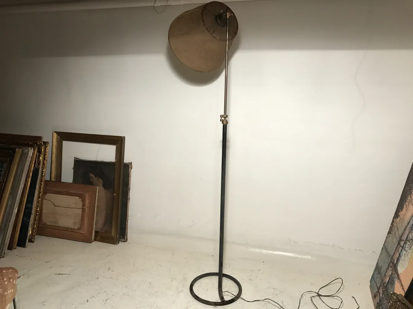 Antique floor lamp in Art Deco style with framed pictures around.