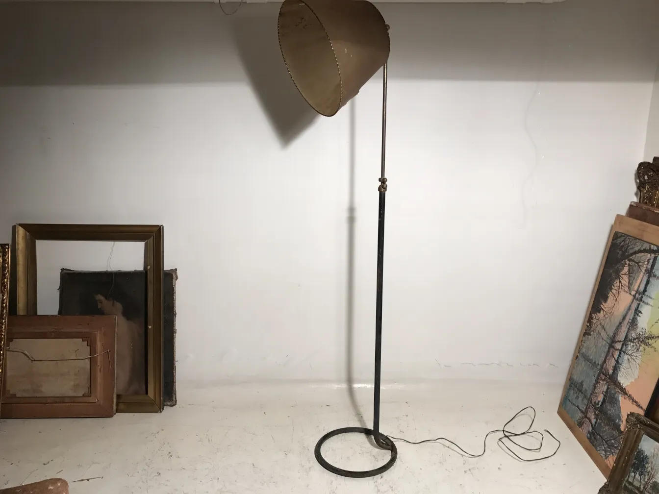 lampada da terra antica con paralume chiaro e design semplice in una stanza con quadri