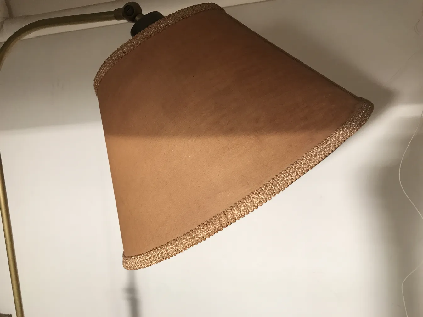 Luminária de pé antiga com cúpula marrom em um ambiente acolhedor.