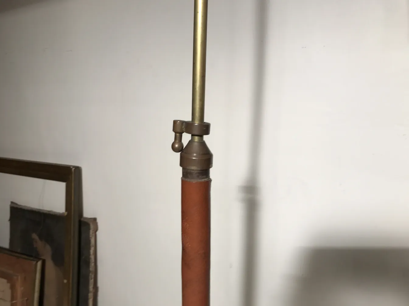 Lampada da terra antica in stile art déco con dettagli in bronzo e pelle in un ambiente accogliente.