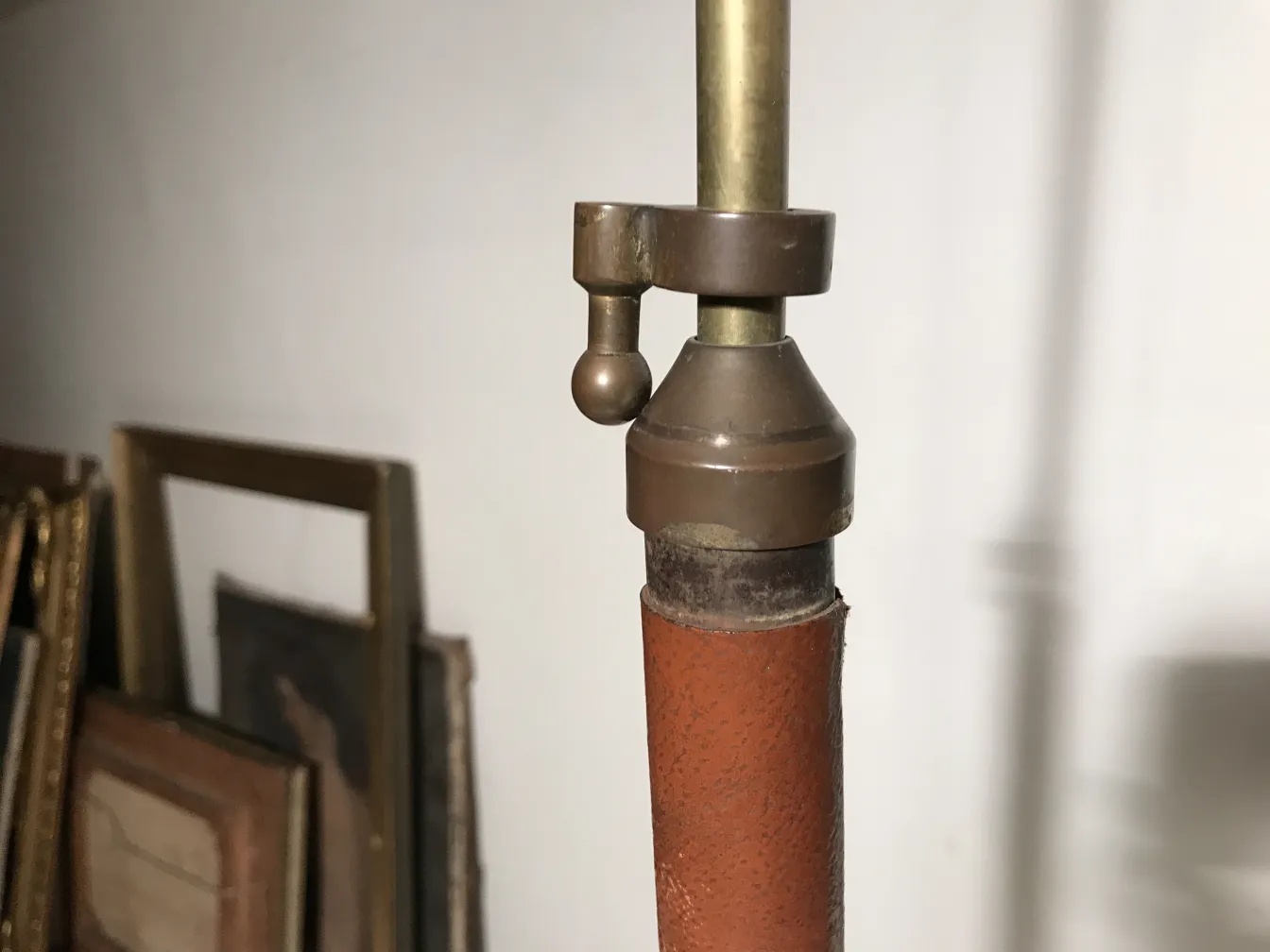 Lampada da terra antica art deco con dettagli metallici, sfondo con quadri appesi