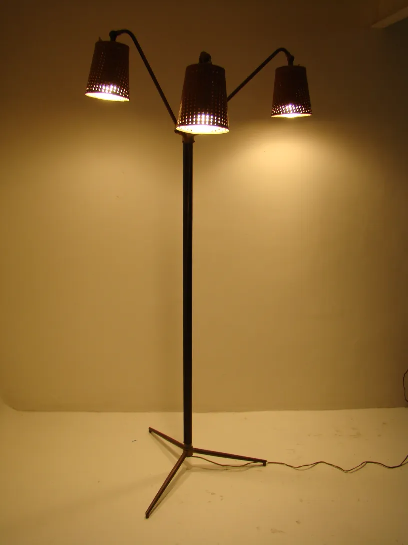 Antiga luminária de pé com três luzes no estilo Art Deco, ambiente acolhedor.