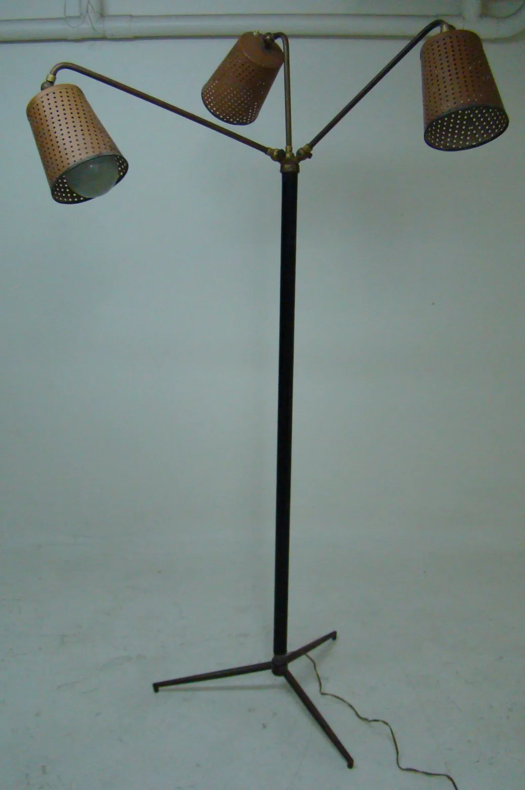 Torchiere ancienne avec un abat-jour perforé et une base stable.