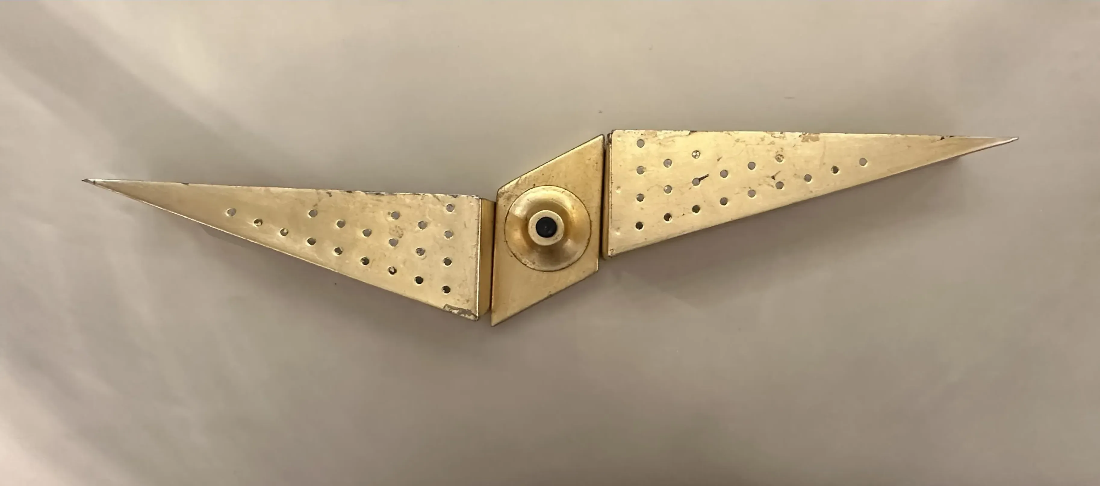 applique da parete antica con forma angolare e dettagli forati