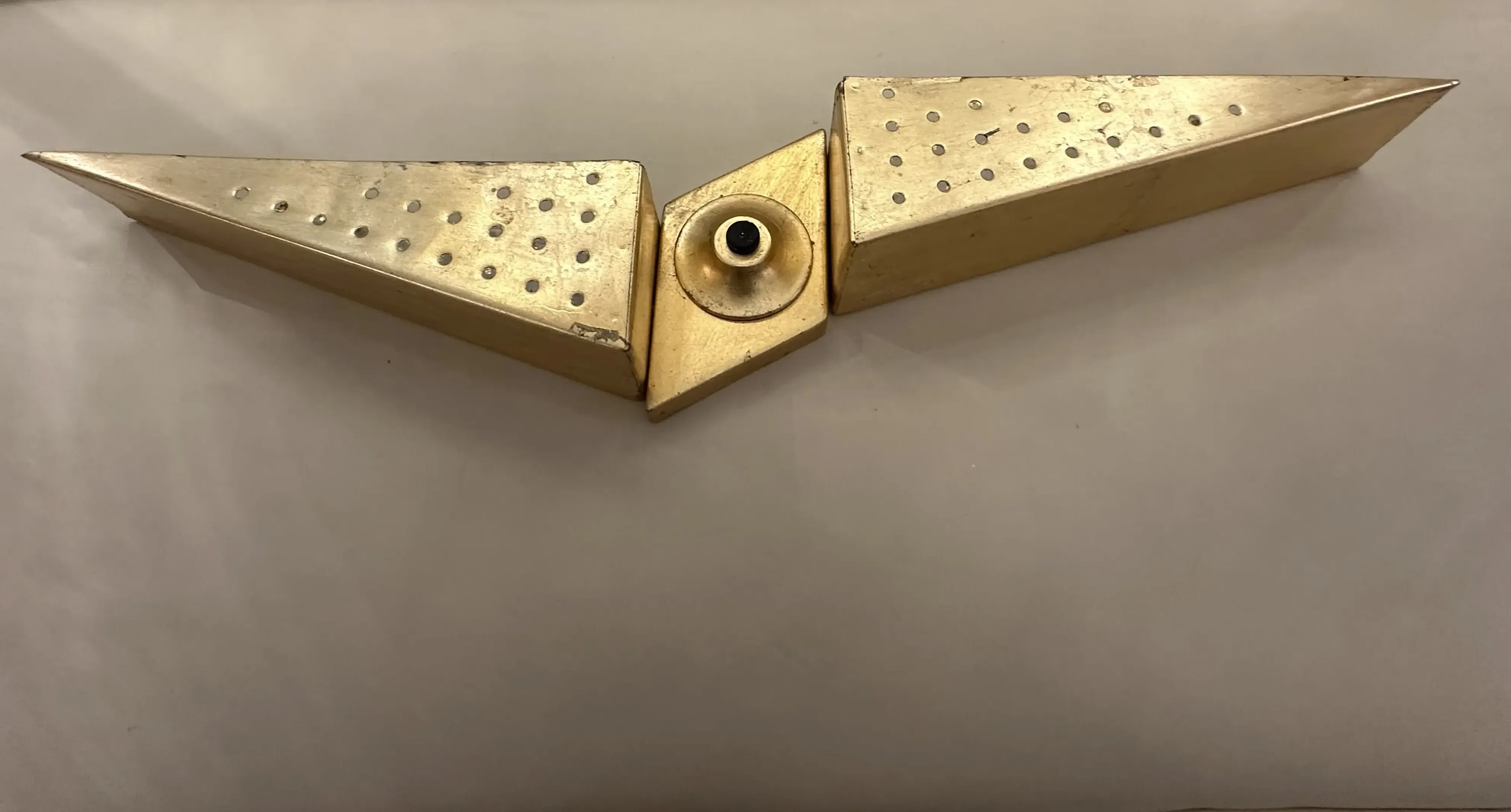 arandela antiga com design triangular e perfurações