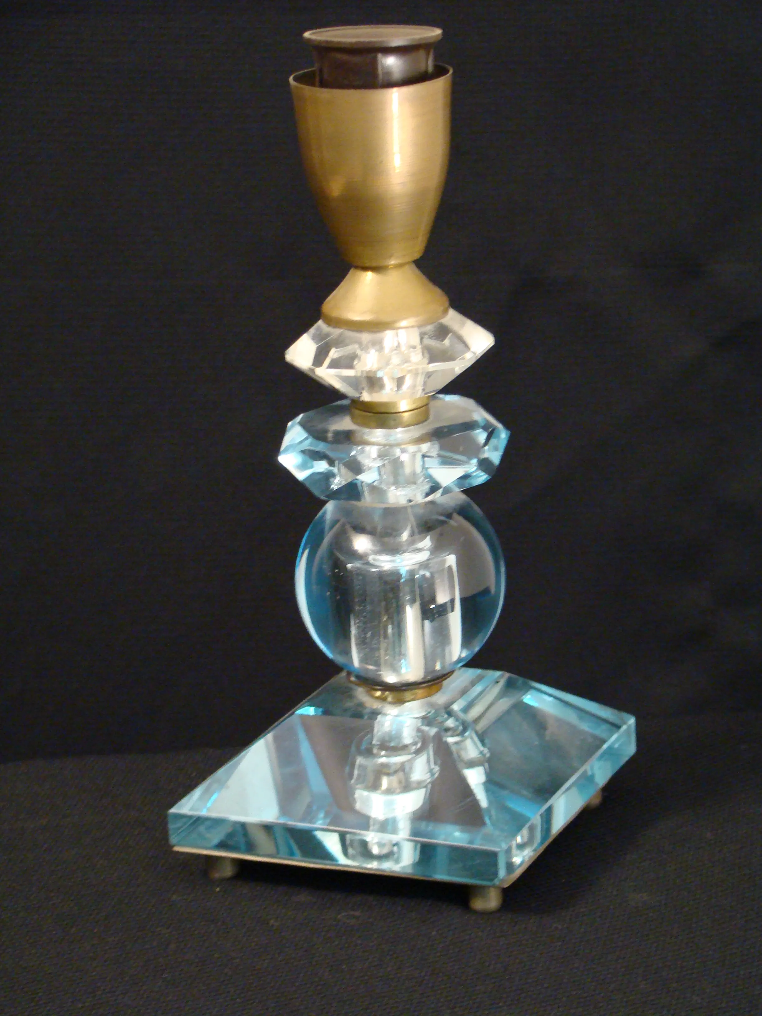 Antike Tischlampe mit Glaselementen, vor dunklem Hintergrund.