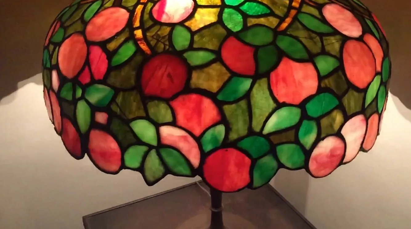 Luminária de mesa antiga no estilo Art Deco com design floral colorido na cúpula.