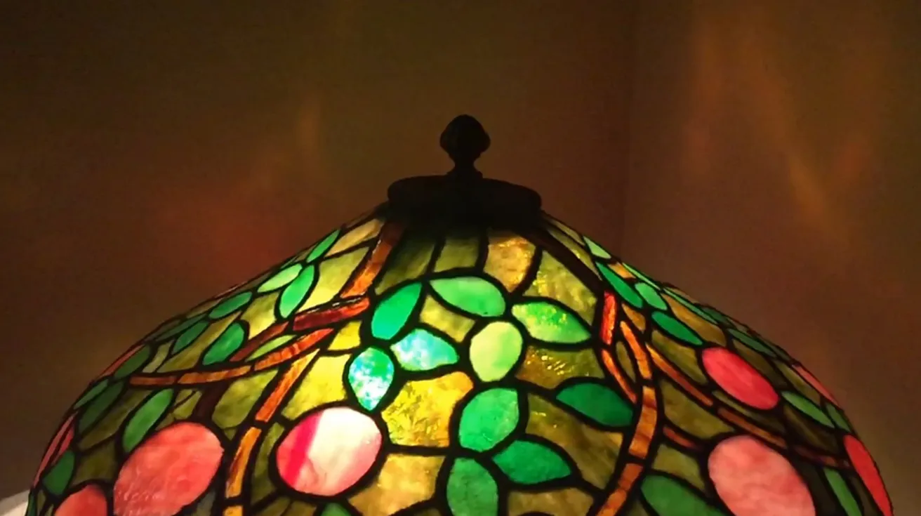 Lámpara de mesa antigua con diseño Art Deco, detalles coloridos.