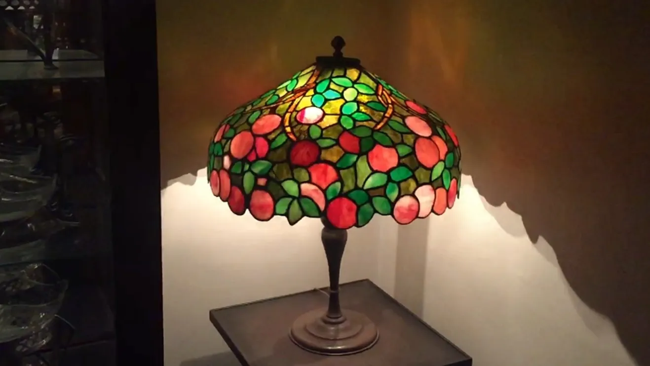 Lámpara de mesa antigua Art Deco con tonalidades verdes y rosas.