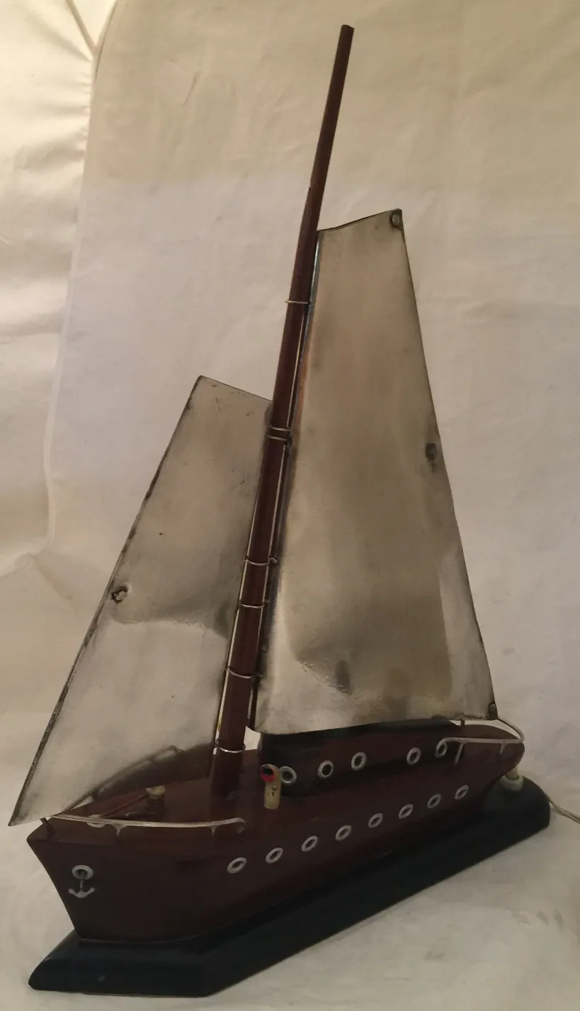 Lampada da tavolo antica a forma di barca con vele metalliche.