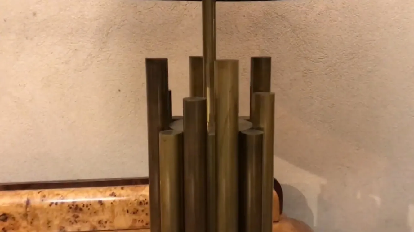 Antike Tischlampe mit künstlerischem Design und Säulenbasis.