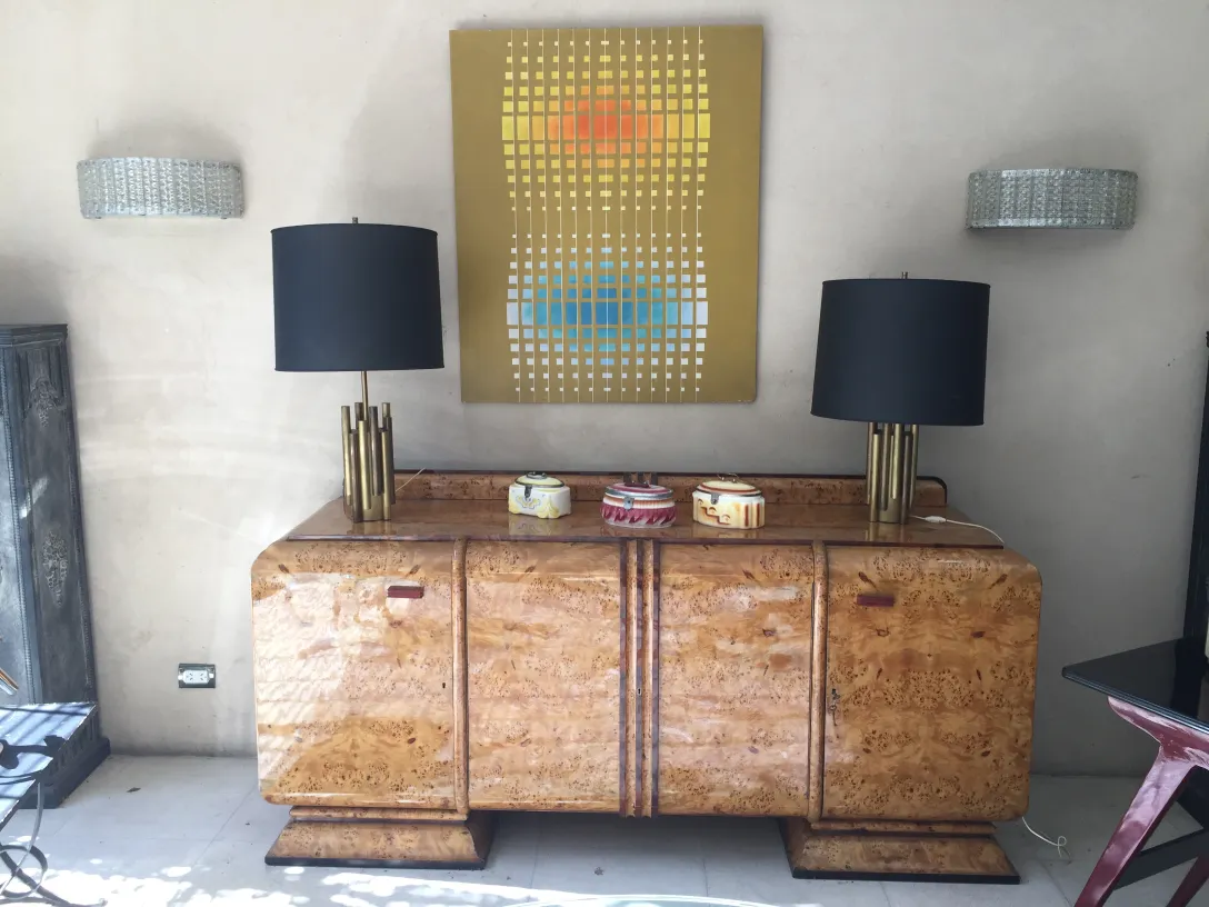 Lámpara de mesa antigua Art Deco con base dorada y pantalla negra, en un elegante ambiente moderno.