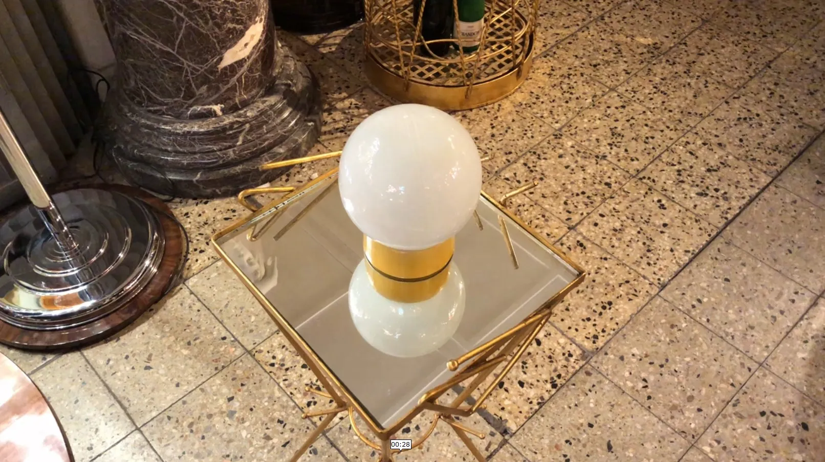 Antiga luminária de mesa com esfera branca, ambiente elegante