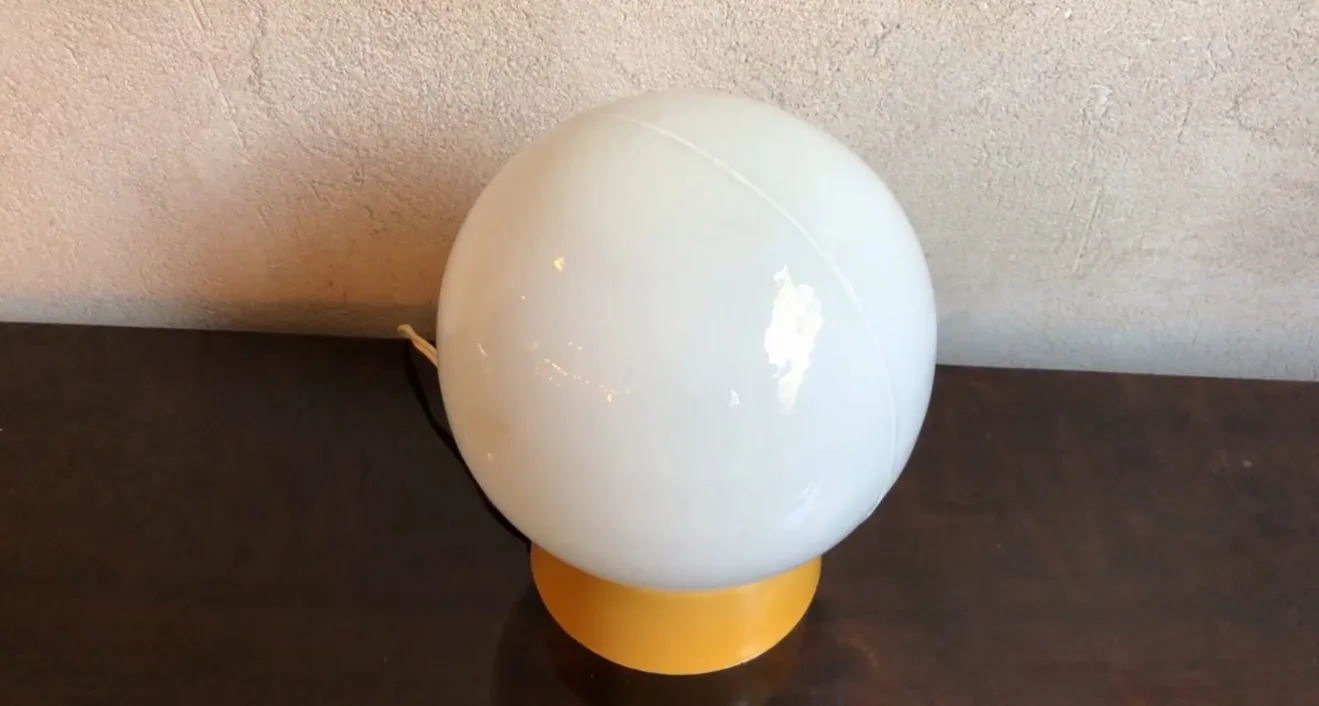 Antike Tischlampe, kugelförmig, in einem warmen Umfeld.