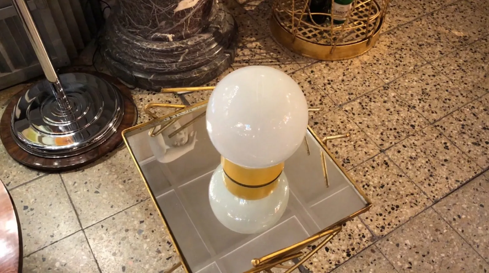 antique table lamp with spherical bulb, golden base, shiny surface