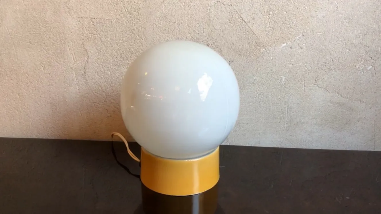 Luminária de mesa antiga esférica com base colorida em um ambiente acolhedor