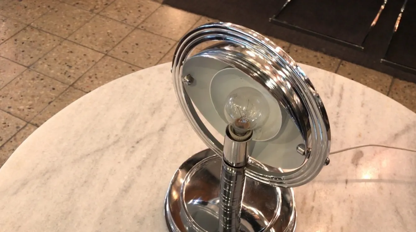 lampada da tavolo antica con base lucida su superficie bianca