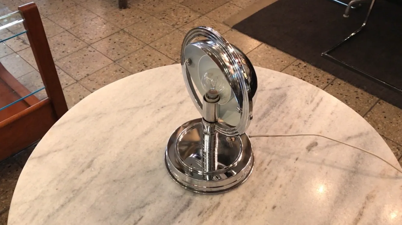 Antike Tischlampe mit Metallbasis auf einem Marmortisch.