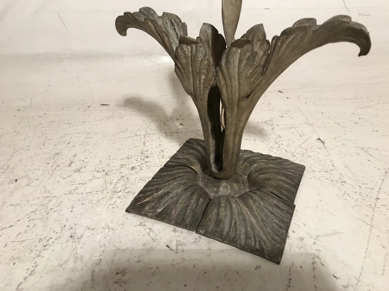 Antique table lamp with art deco style featuring a floral design and decorative base.