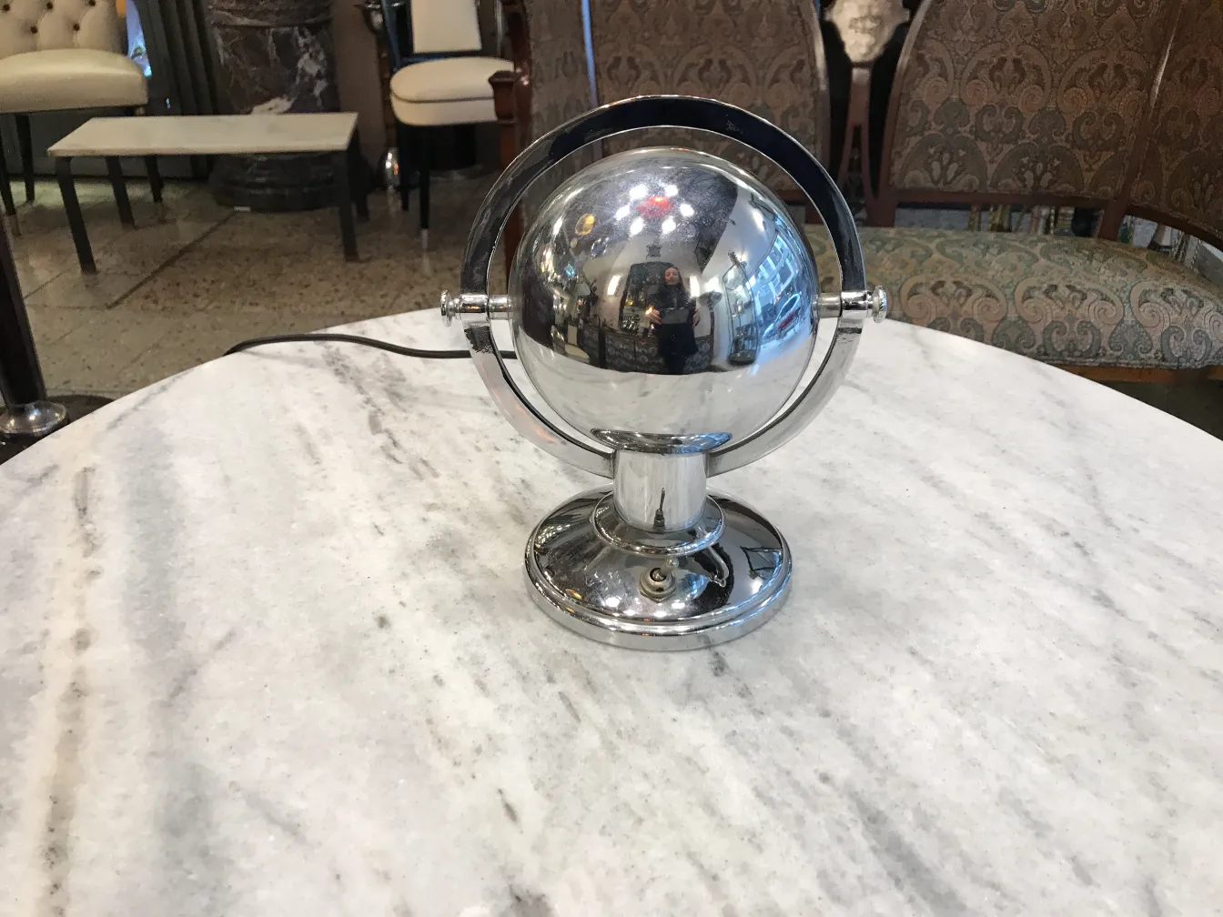 Antique table lamp in Art Deco style with shiny metallic base in a cozy setting.