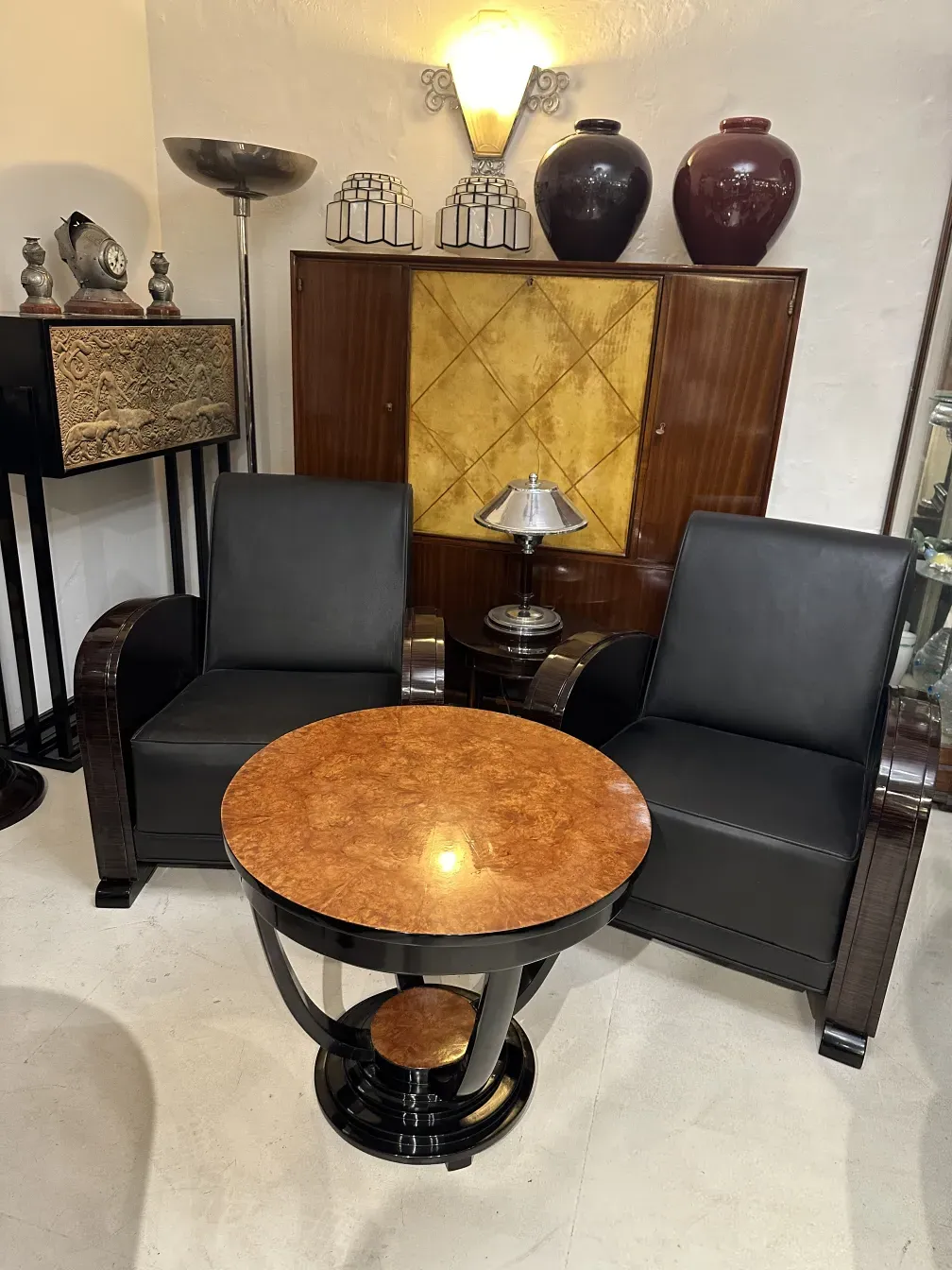 antique bar cabinet in an elegant setting with black leather chairs
