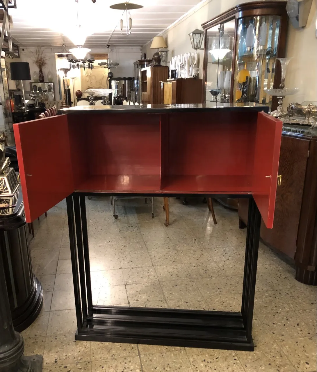 mobile bar antico rosso con interno spazioso, circondato da altri mobili vintage