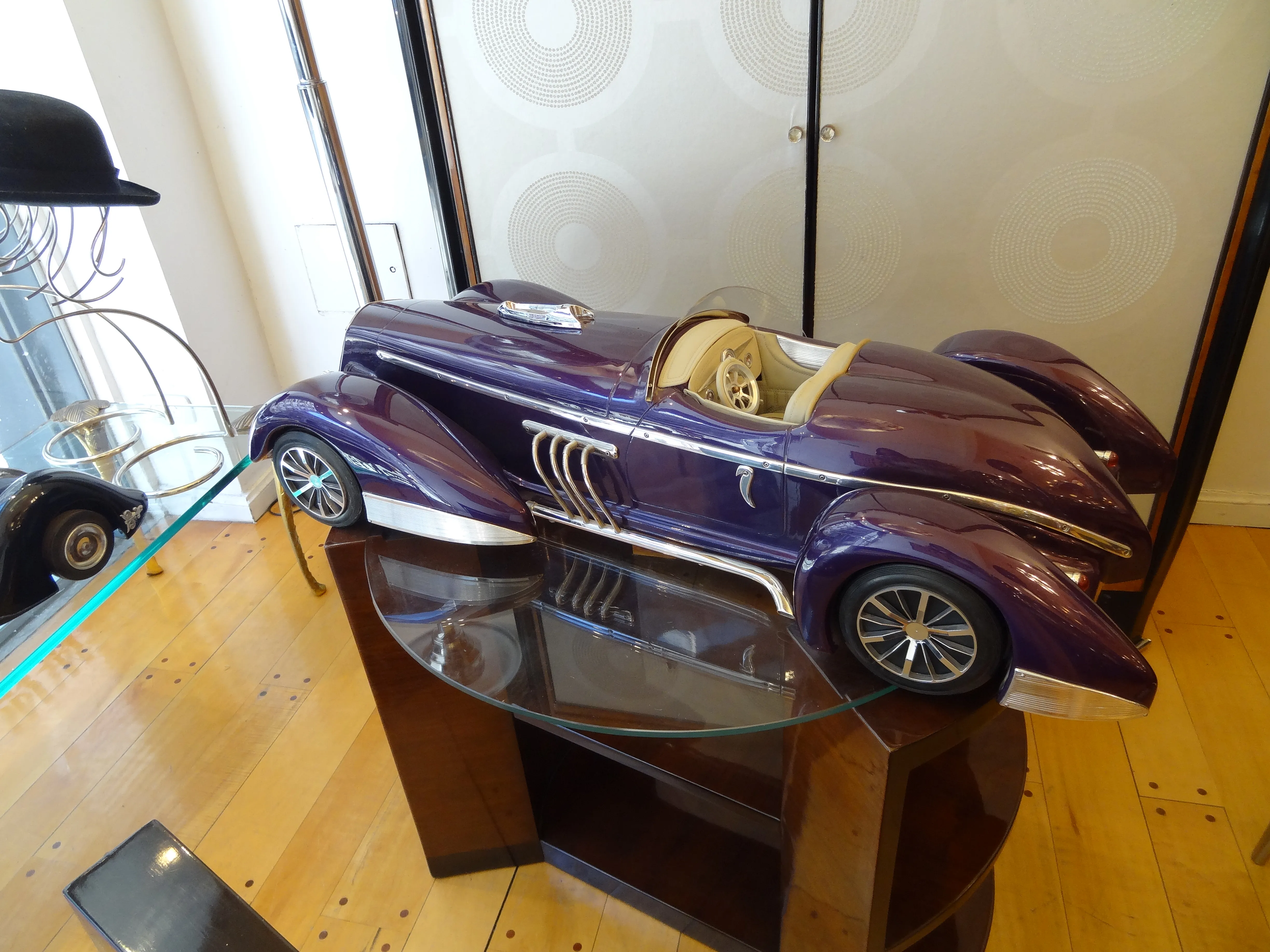 modèle de voiture ancienne violette avec des détails argentés exposé sur une table