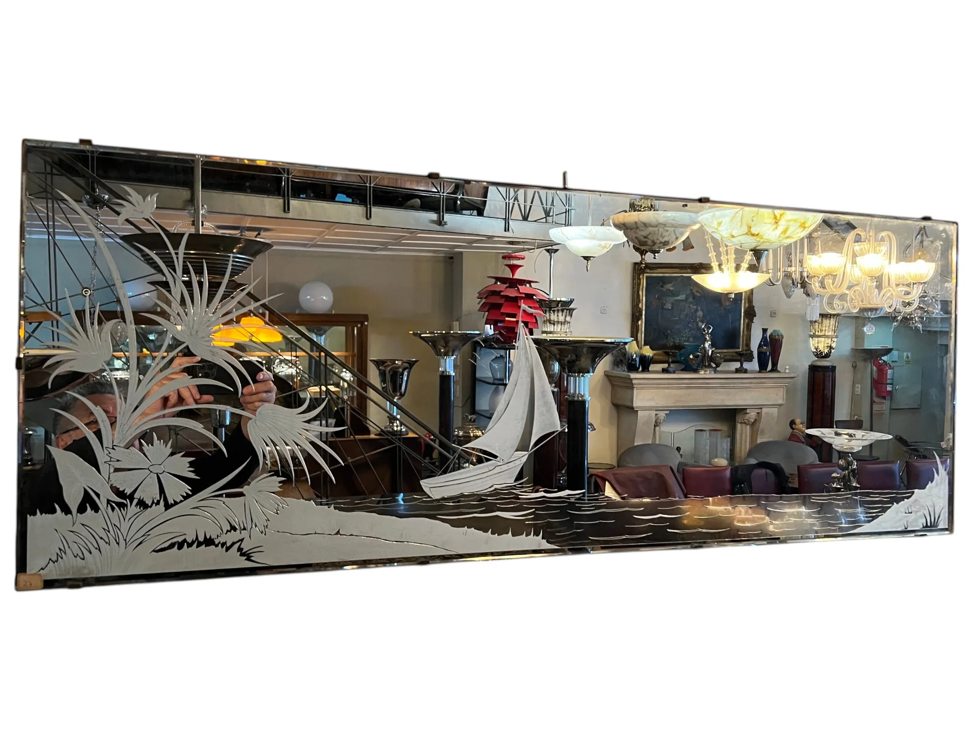 antique mirror decorated with floral designs and a boat