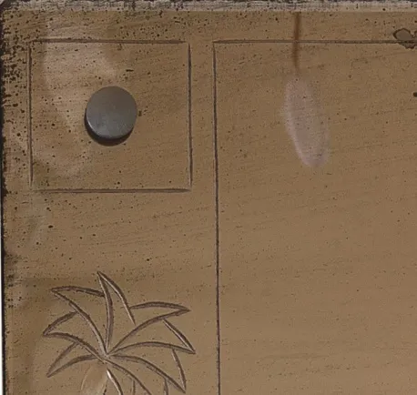 antique mirror decorated with a palm tree design.