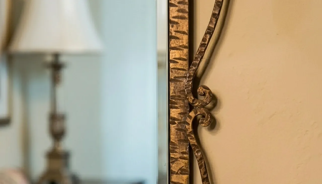 antique decorative mirror with intricate golden frame, in a classic setting with lamp