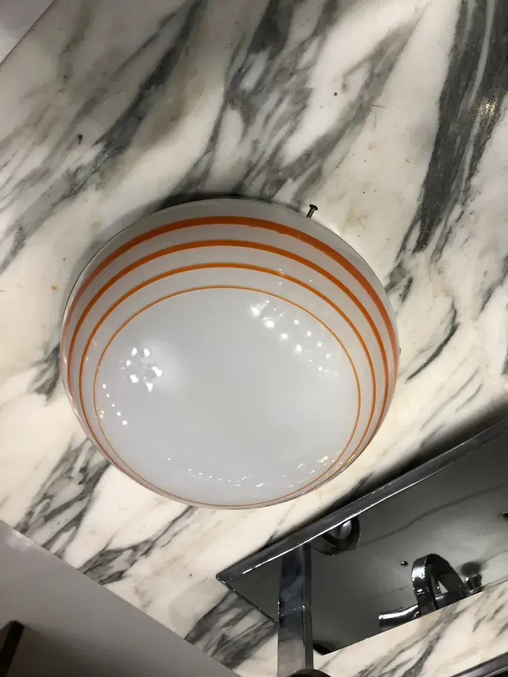 Três luzes de teto antigas com listras laranjas em fundo branco