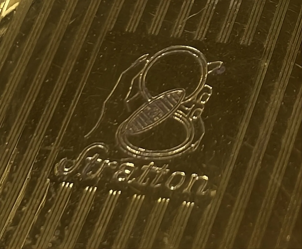 polvera antigua con diseño elegante y logo de stratton