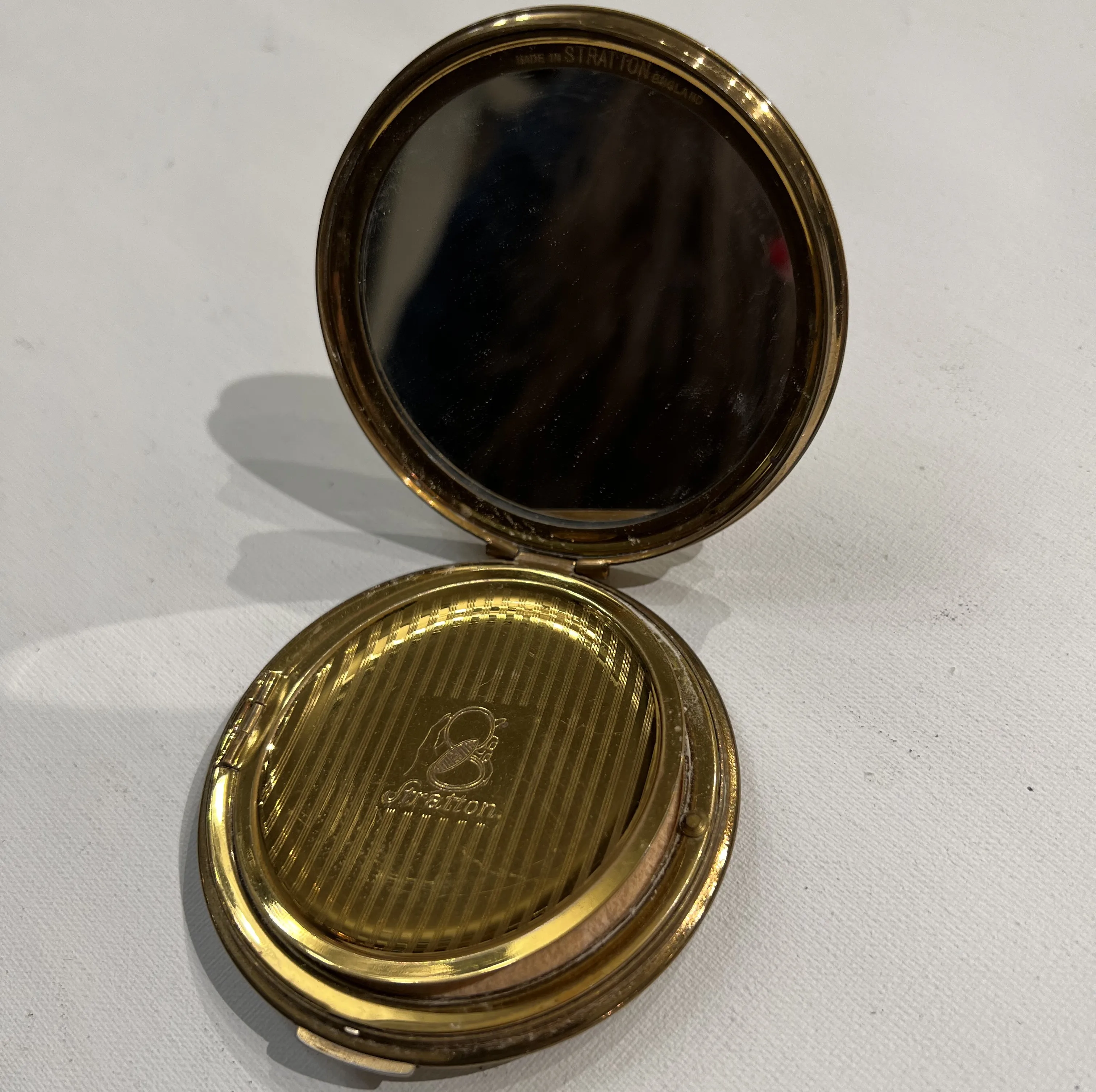 compact ancien avec miroir et design doré, stratton england