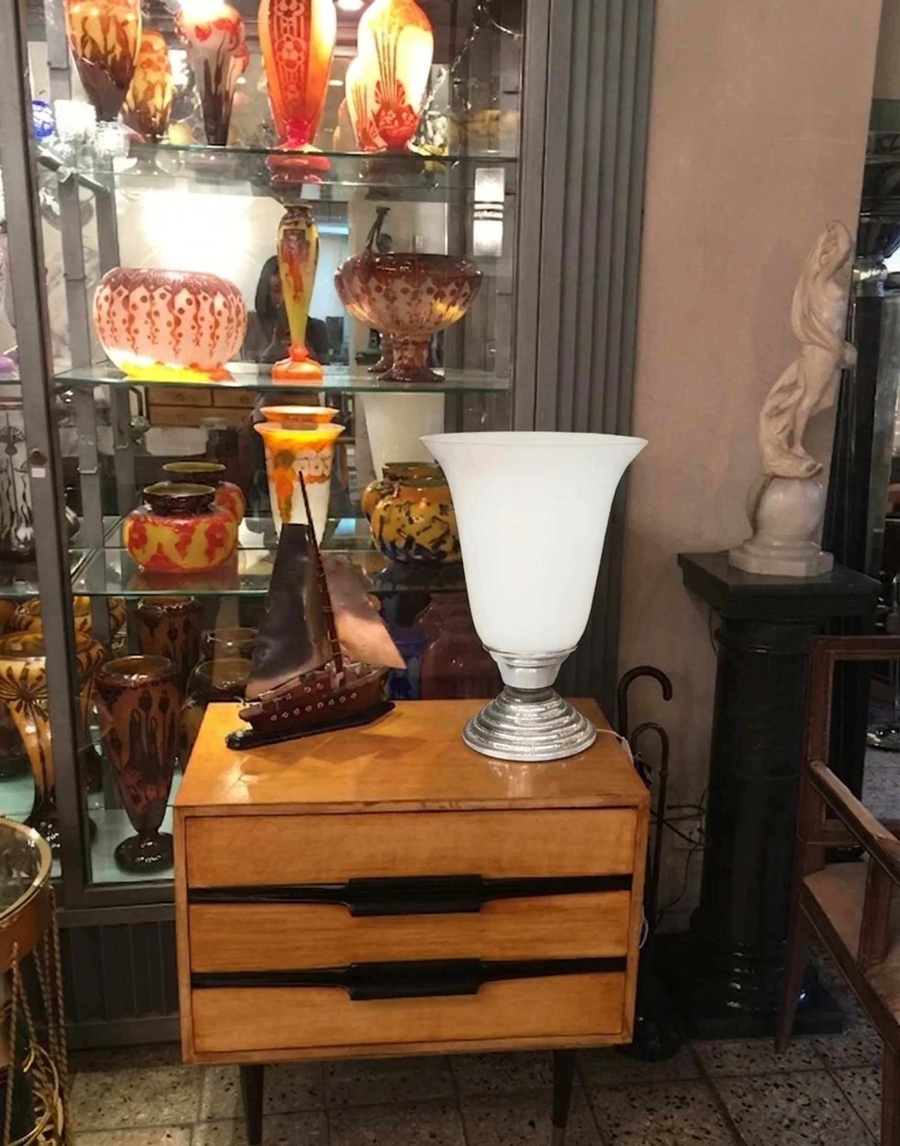 lampada da tavolo antica bianca accanto a un mobile vintage, decorazioni colorate