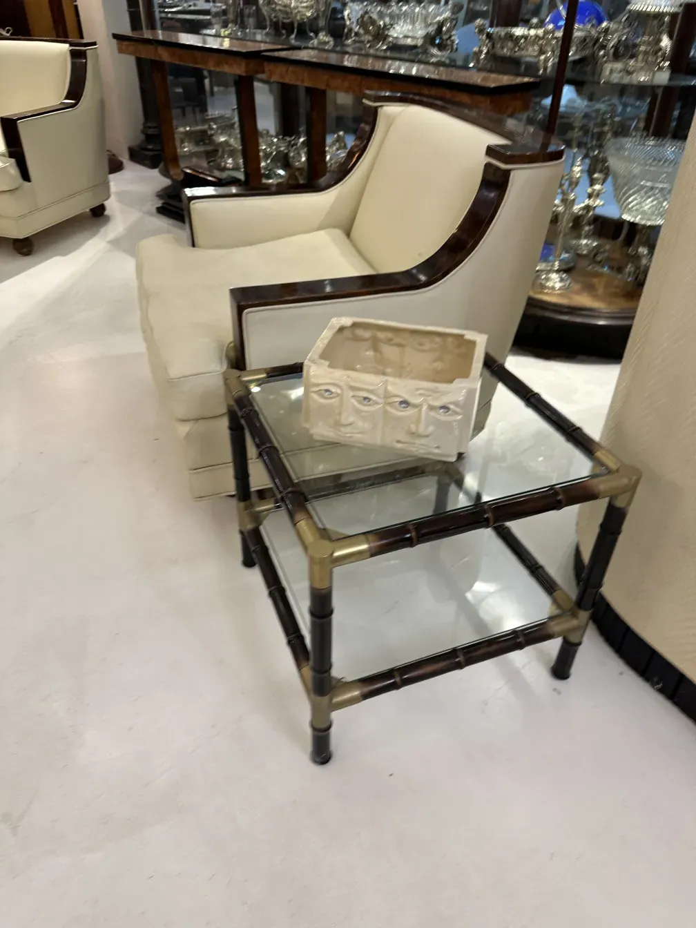 3 mesas de centro antigas com design elegante e um objeto decorativo ao fundo.