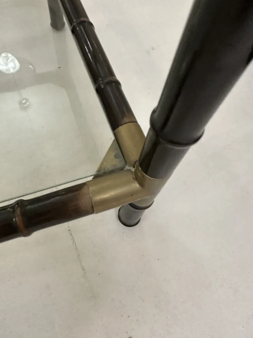 View of the legs of three antique coffee tables with brass details.