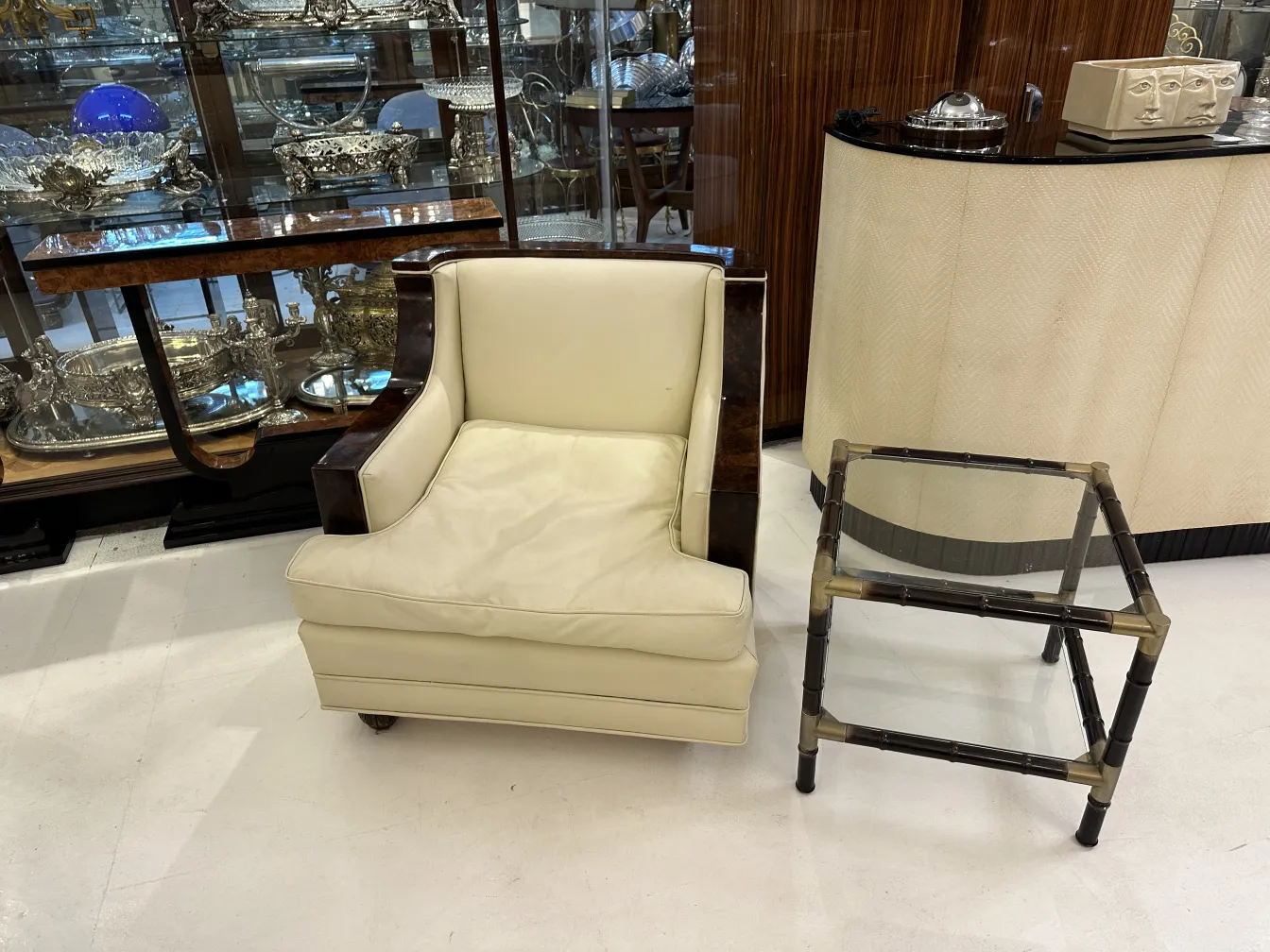 Trois tables basses antiques à côté d'un fauteuil dans un cadre élégant