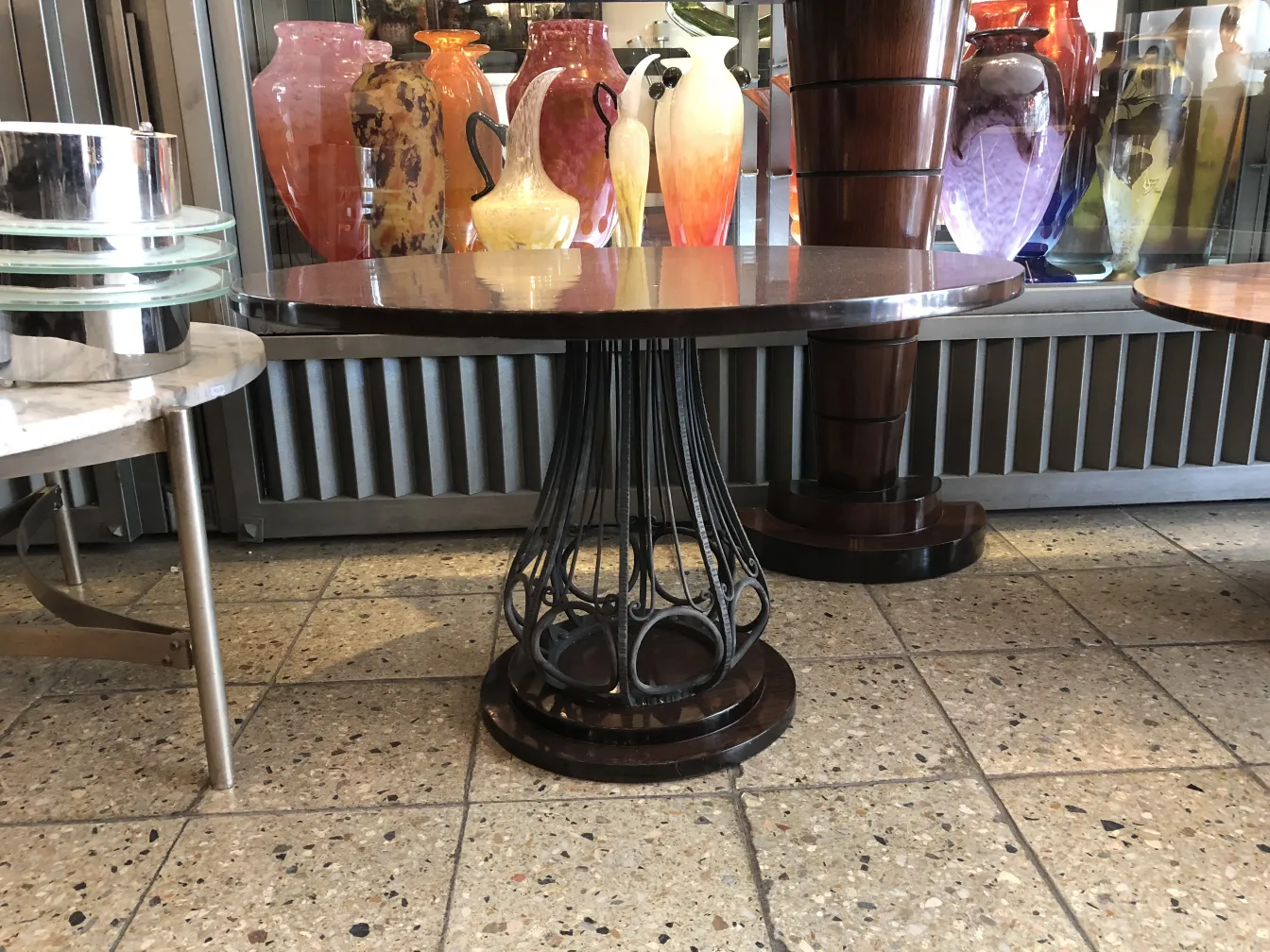Deux petites tables antiques avec des éléments décoratifs, entourées d'objets