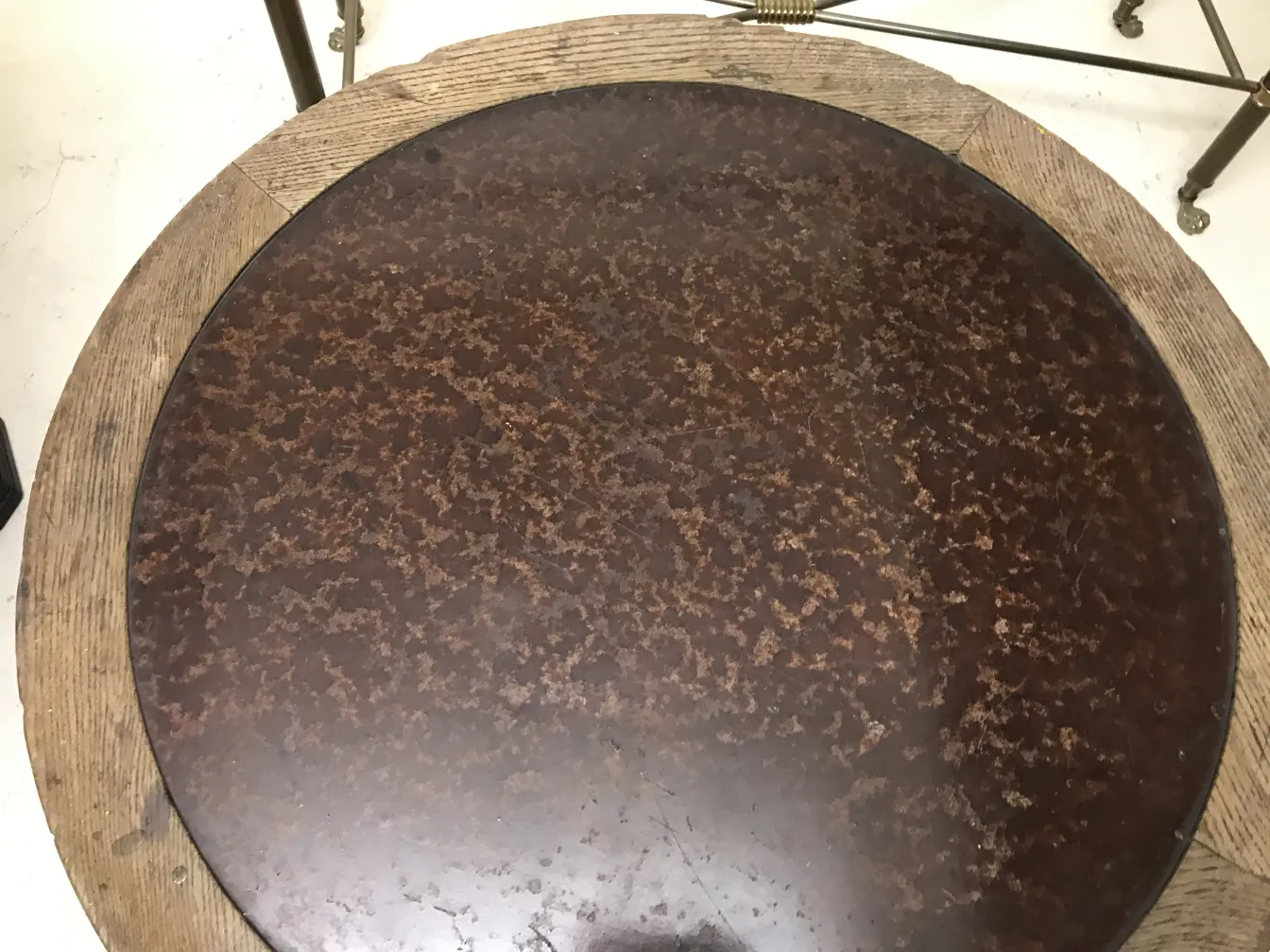 Mesa ratona antigua con superficie oscura y bordes claros en un ambiente elegante.