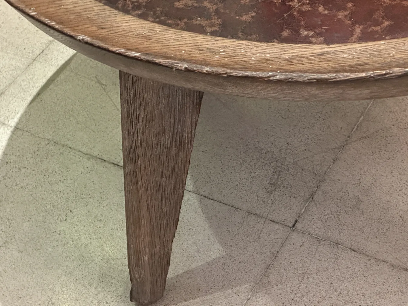 Mesa ratona antigua con patas cónicas y diseño simple, parte de un entorno elegante.