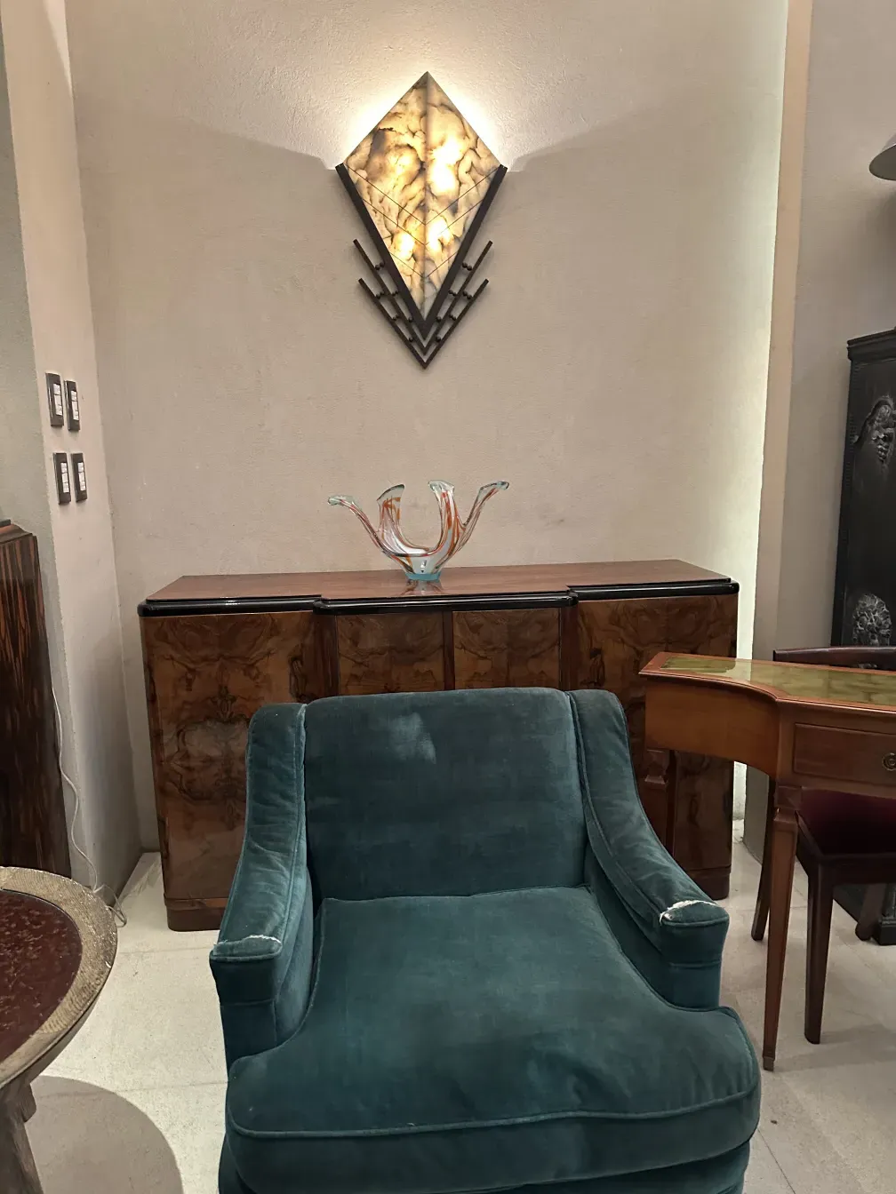 Mesa de centro antiga de estilo Charlotte Perriand em um ambiente elegante, decorada com um vaso colorido.