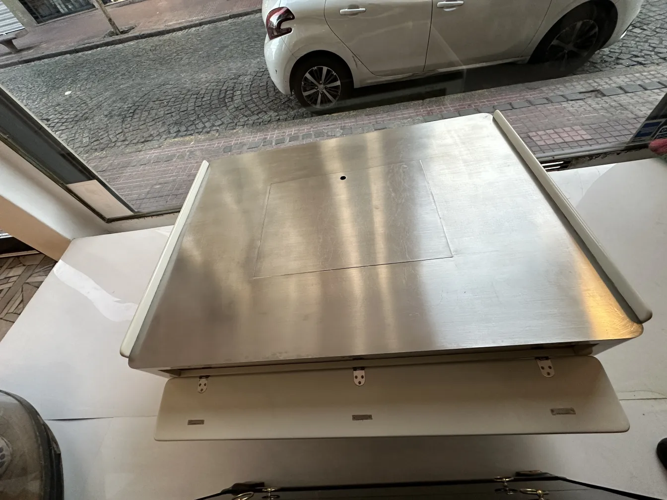 Tavolino da caffè antico con design moderno, stile vico magistretti, completato da un ambiente urbano.