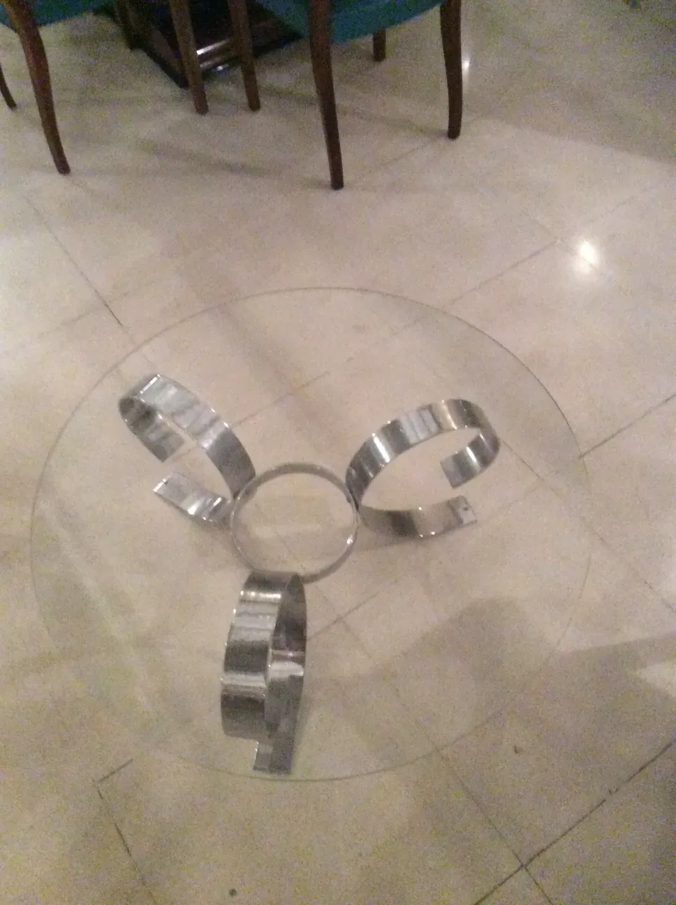 Tavolino da caffè antico con base scultorea. Colore argentato e forma rotonda al centro.