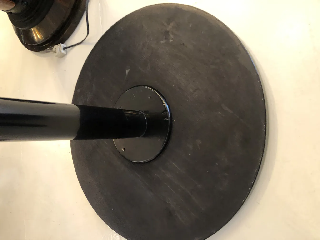 tavolino antico rotondo con base nera su sfondo chiaro