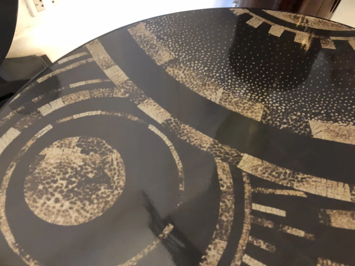 Tavolino antico con un design geometrico sulla superficie.