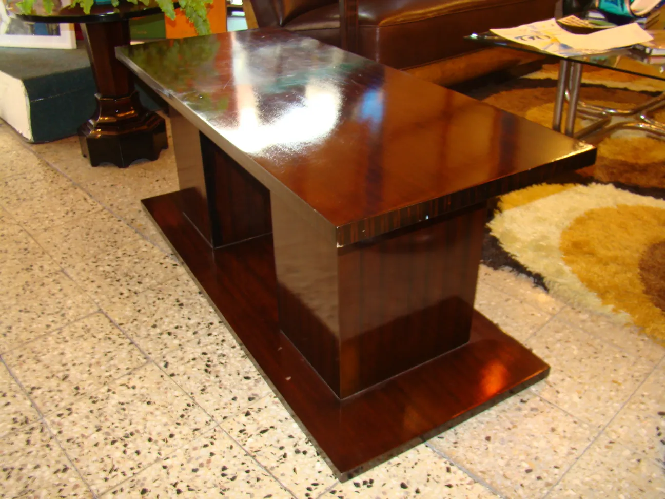 Antique coffee table with polished surface and decorative base
