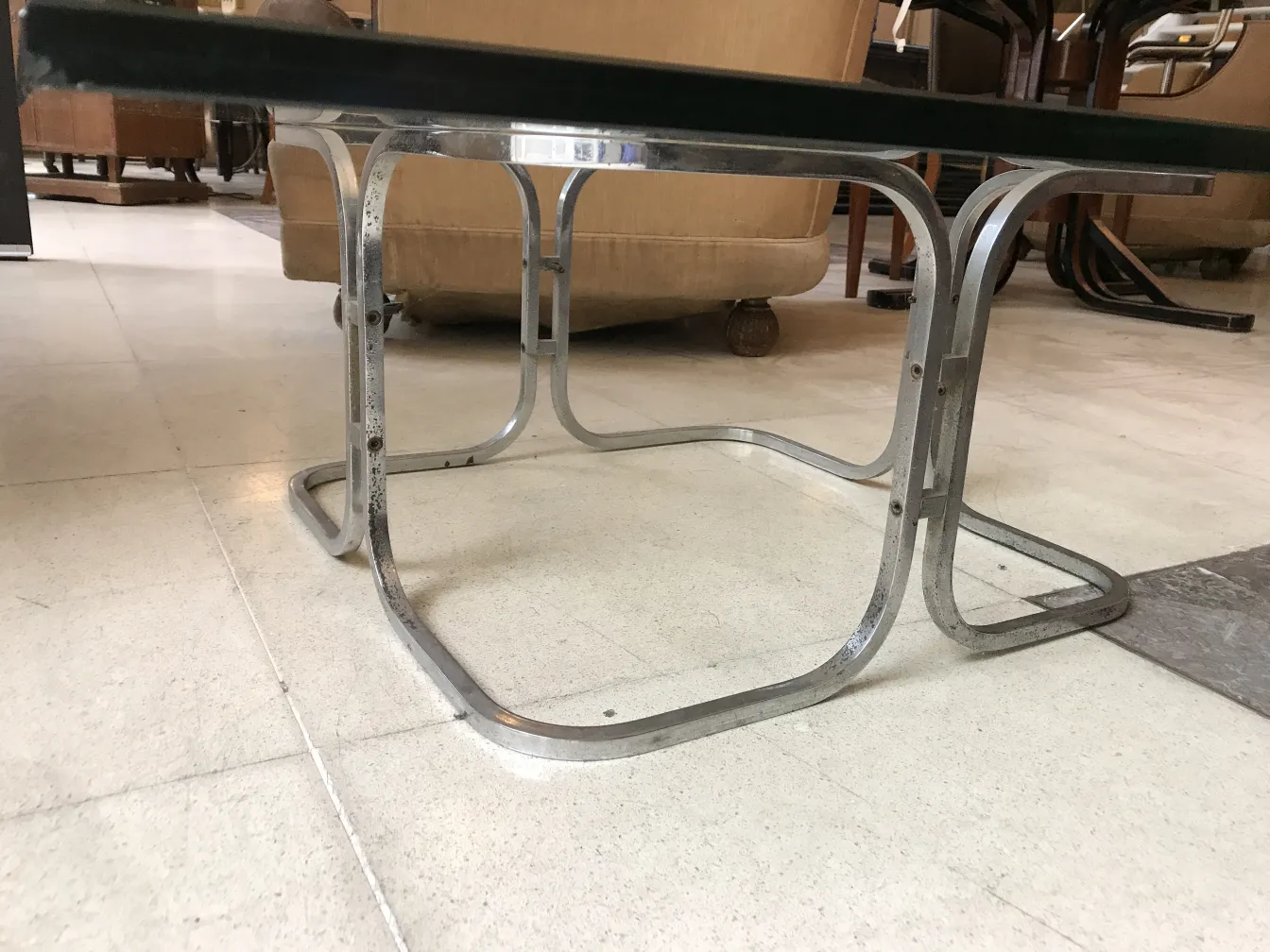 antique coffee table with metal legs and black surface in a cozy environment