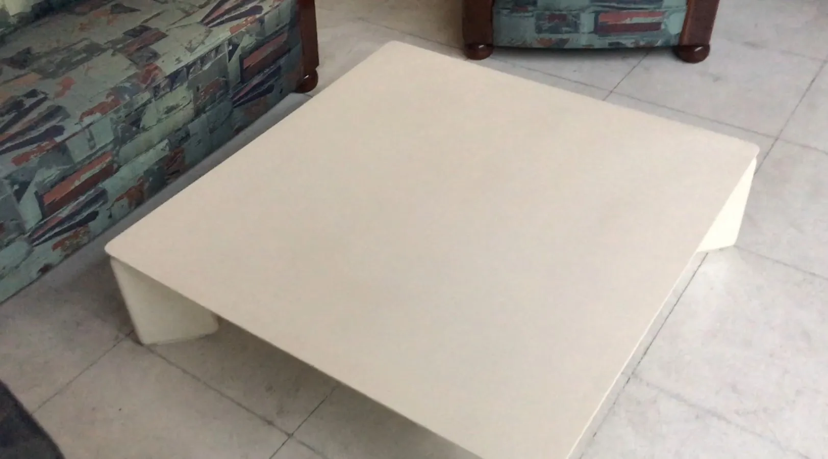 Table basse blanche carrée dans un cadre accueillant avec des canapés.