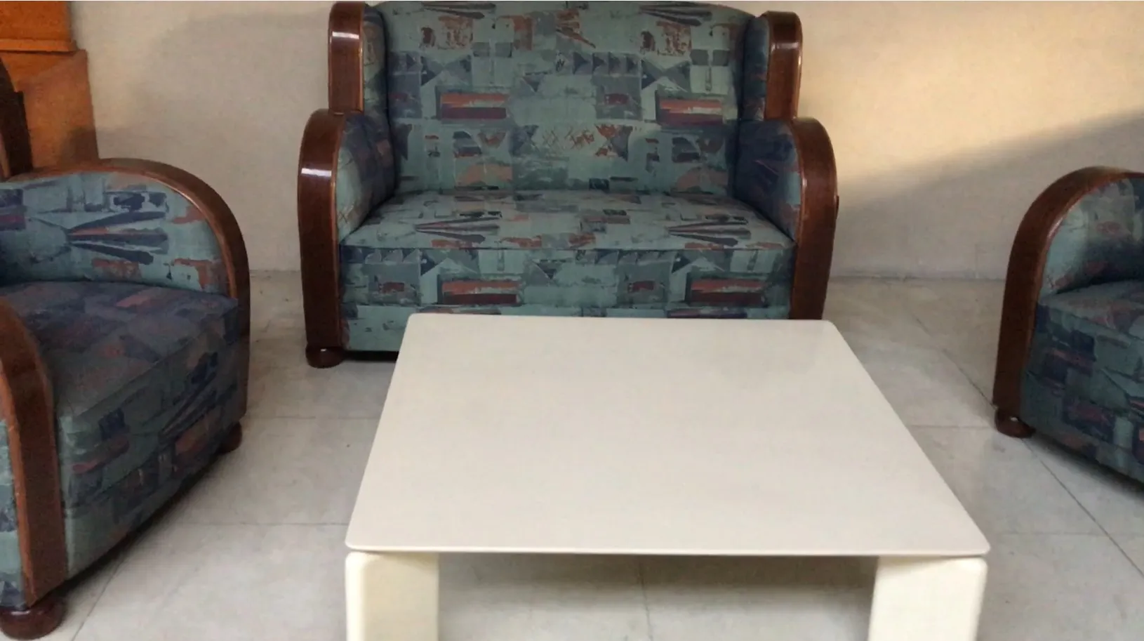 Table basse ancienne dans un cadre accueillant avec des fauteuils colorés